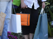 FILE - Shoppers carry bags after making purchases in Bradenton, Fla., Feb. 9, 2024. &ldquo;Buy now, pay later&rdquo; services are a popular way that shoppers pay for goods. (AP Photo/Gene J.