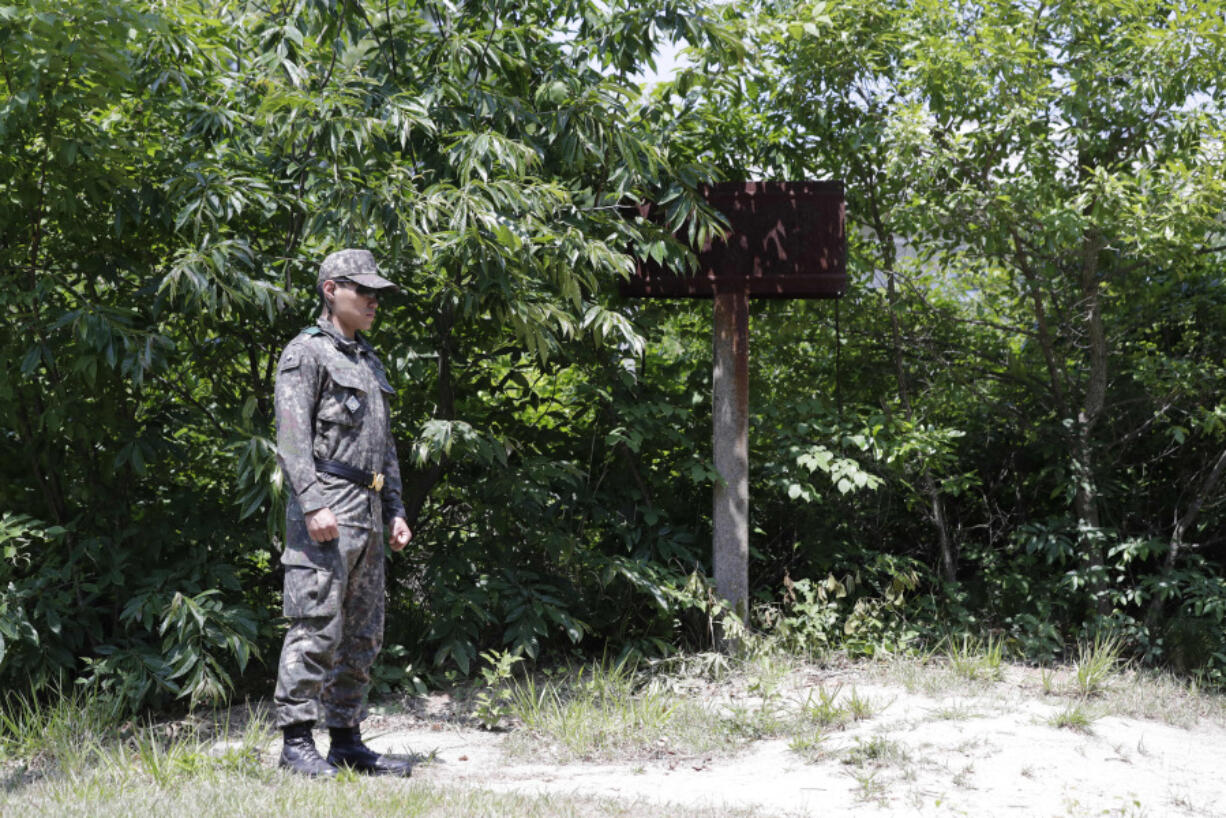 FILE - A South Korean soldier stands guard near a sign of military demarcation line at the southern side of the border village of Panmunjom in the Demilitarized Zone, South Korea, Wednesday, June 12, 2019. Don&rsquo;t believe the name: The Demilitarized Zone between the two rival Koreas might be the most heavily armed place on earth. Two million mines, barbed wire fences, tank traps and tens of thousands of troops from both countries patrol a divided swath of land 248 kilometers (154 miles) long and 4 kilometers (2.5 miles) wide.