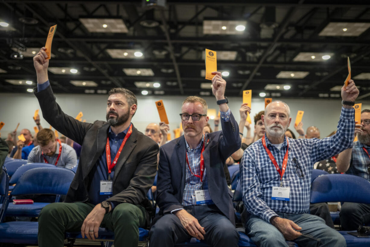 Messengers raise their ballots in support of a motion put up for vote during a Southern Baptist Convention annual meeting Tuesday, June 11, 2024, in Indianapolis.