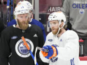 Edmonton Oilers center Connor McDavid, right, and defenseman Mattias Ekholm talk during hockey practice before Media Day for the Stanley Cup Finals, Friday, June 7, 2024, in Sunrise, Fla. The Oilers take on the Florida Panthers in Game 1 on Saturday in Sunrise.