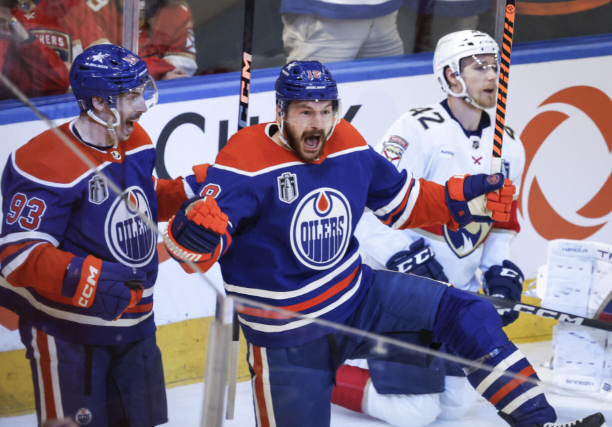 Edmonton Oilers&rsquo; Zach Hyman (18) celebrates his goal against the Florida Panthers with Ryan Nugent-Hopkins (93) as Panthers&rsquo; Gustav Forsling (42) skates past during the second period of Game 6 of the NHL hockey Stanley Cup Final, Friday, June 21, 2024, in Edmonton, Alberta.