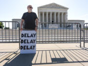 Activist Bill Christeson protests in front of the Supreme Court as decisions are announced, on Capitol Hill in Washington, Friday, June 21, 2024. The justices are still weighing whether former President Donald Trump is immune from criminal prosecution in the election interference case against him, roughly two months after hearing arguments. (AP Photo/J.