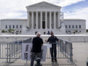 A Supreme Court police officer talks with a demonstrator at a barricade outside the Supreme Court on Thursday, June 27, 2024, in Washington.