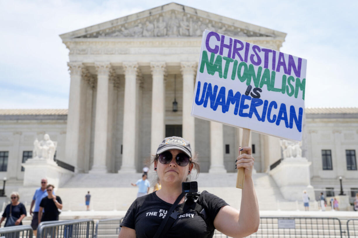 Michelle Peterson, of Washington, protests and calls for the recusal of Supreme Court Justices Samuel Alito and Clarence Thomas in cases relating to Jan. 6 and former President Donald Trump, outside the Supreme Court, Tuesday, June 25, 2024, in Washington.