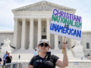 Michelle Peterson, of Washington, protests and calls for the recusal of Supreme Court Justices Samuel Alito and Clarence Thomas in cases relating to Jan. 6 and former President Donald Trump, outside the Supreme Court, Tuesday, June 25, 2024, in Washington.