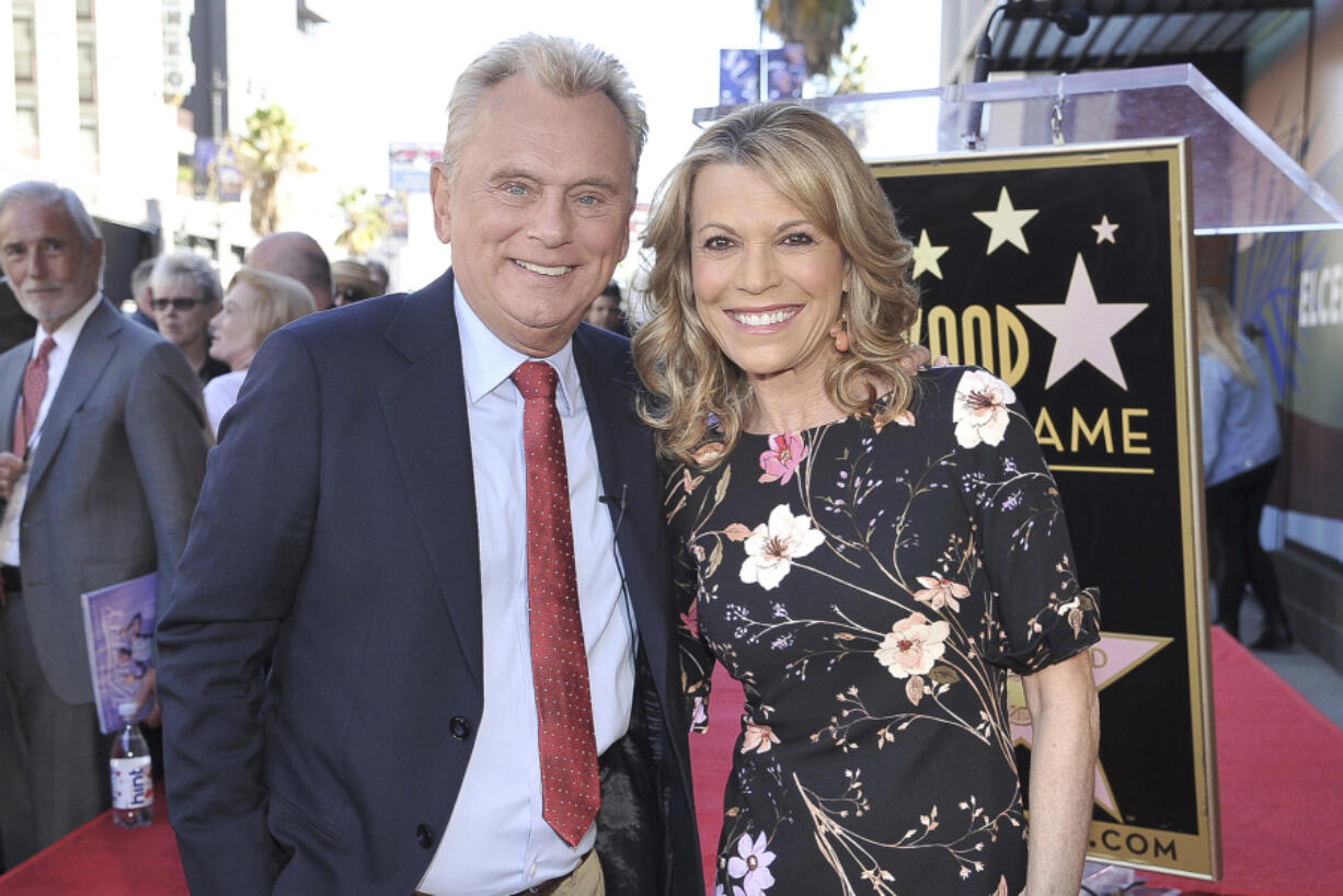 FILE - Pat Sajak, left, and Vanna White, from &ldquo;Wheel of Fortune,&rdquo; attend a ceremony honoring Harry Friedman with a star on the Hollywood Walk of Fame in Los Angeles on Nov. 1, 2019.