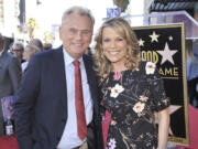 FILE - Pat Sajak, left, and Vanna White, from &ldquo;Wheel of Fortune,&rdquo; attend a ceremony honoring Harry Friedman with a star on the Hollywood Walk of Fame in Los Angeles on Nov. 1, 2019.