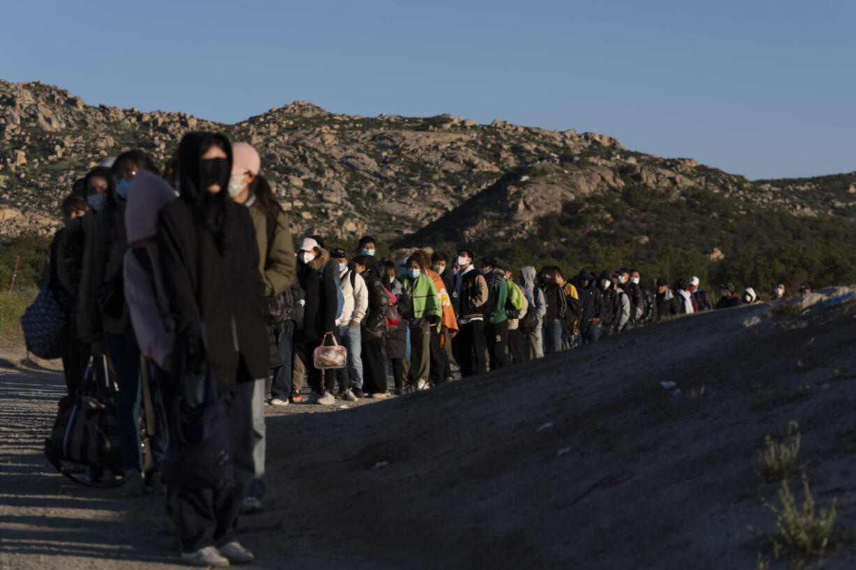 Chinese migrants wait to be processed after crossing the border with Mexico on May 8, 2024, near Jacumba Hot Springs, Calif. The U.N.&rsquo;s refugee agency has expressed concern over plans for new asylum restrictions in the United States. President Joe Biden on Tuesday unveiled plans to enact immediate significant restrictions on migrants seeking asylum at the U.S.-Mexico border as the White House tries to neutralize immigration as a political liability ahead of the November elections.