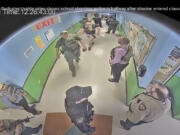 FILE - In this photo from surveillance video provided by the Uvalde Consolidated Independent School District via the Austin American-Statesman, authorities stage in a hallway as they respond to the shooting at Robb Elementary School in Uvalde, Texas, May 24, 2022. The former Uvalde schools police chief and another former officer have been indicted over their role in the slow police response to the 2022 massacre in a Texas elementary school that left 19 children and two teachers dead, according to multiple reports Thursday, June 27, 2024.