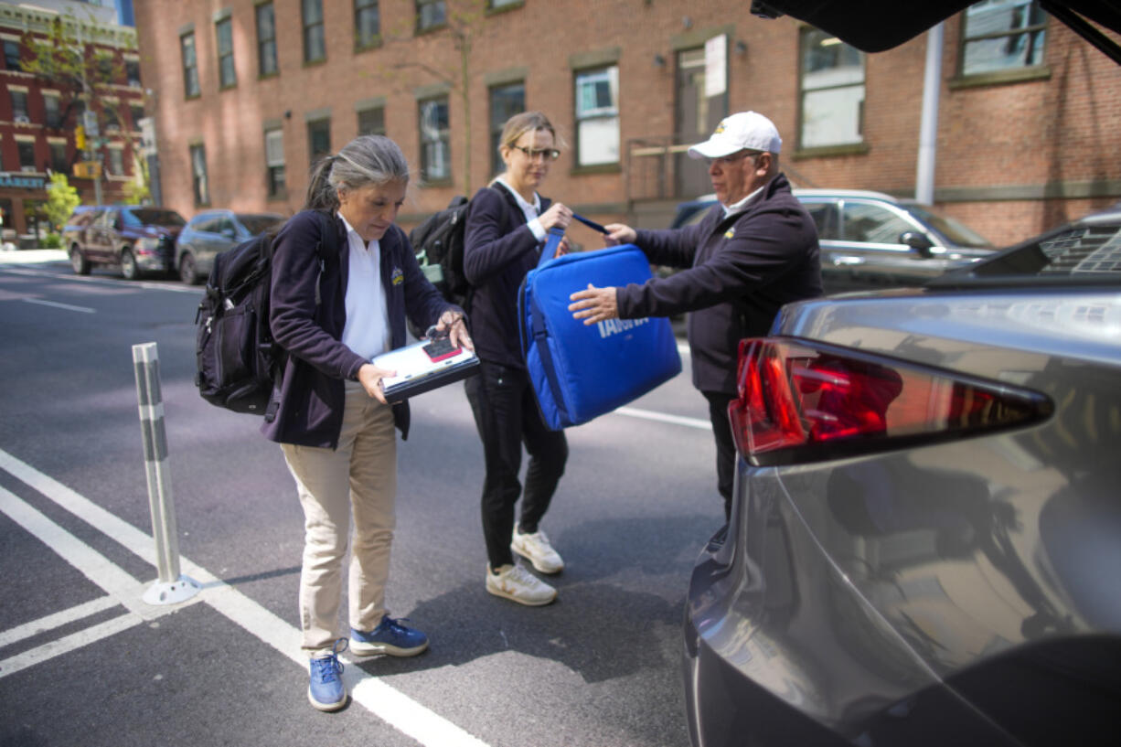 Dr. Amy Attas, left, and licensed veterinary technician Jeanine Lunz, center arrive at a clients apartment building April 23 in New York.