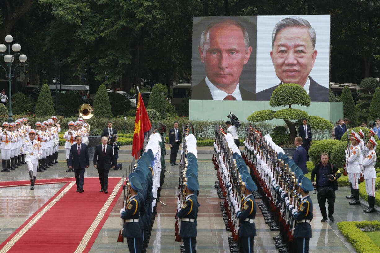 Vietnamese President To Lam, left on red carpet, and his Russian counterpart Vladimir Putin, right on red carpet, review the guard of honor at the Presidential Palace in Hanoi, Vietnam, Thursday, June 20, 2024.