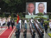 Vietnamese President To Lam, left on red carpet, and his Russian counterpart Vladimir Putin, right on red carpet, review the guard of honor at the Presidential Palace in Hanoi, Vietnam, Thursday, June 20, 2024.