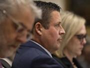 Auburn Police Officer Jeffrey Nelson, center, is flanked by two of his defense attorneys as Nelson&rsquo;s murder trial gets underway, Thursday, May 16, 2024 in Kent, Wash. On the left is Tim Leary, to the right is Emma Scanlan. Nelson is charged with murder in the death of a 26-year-old man outside a convenience store.