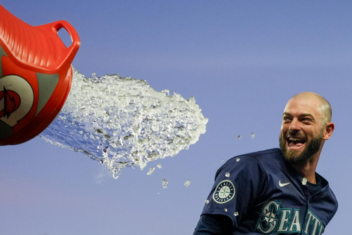 Seattle Mariners&#039; Mitch Haniger tries to avoid a dousing during the celebration of the team&#039;s 2-1 win over the Chicago White Sox in 10 innings in a baseball game Wednesday, June 12, 2024, in Seattle. Haniger drove in the winning run.