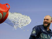 Seattle Mariners&#039; Mitch Haniger tries to avoid a dousing during the celebration of the team&#039;s 2-1 win over the Chicago White Sox in 10 innings in a baseball game Wednesday, June 12, 2024, in Seattle. Haniger drove in the winning run.