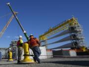 FILE - A generator and its blades are prepared for transport to the open ocean for the South Fork Wind farm in New London, Conn., Dec. 4, 2023. The World Bank upgraded the outlook for the global economy in 2024, citing continued resilience and strength in the United States.