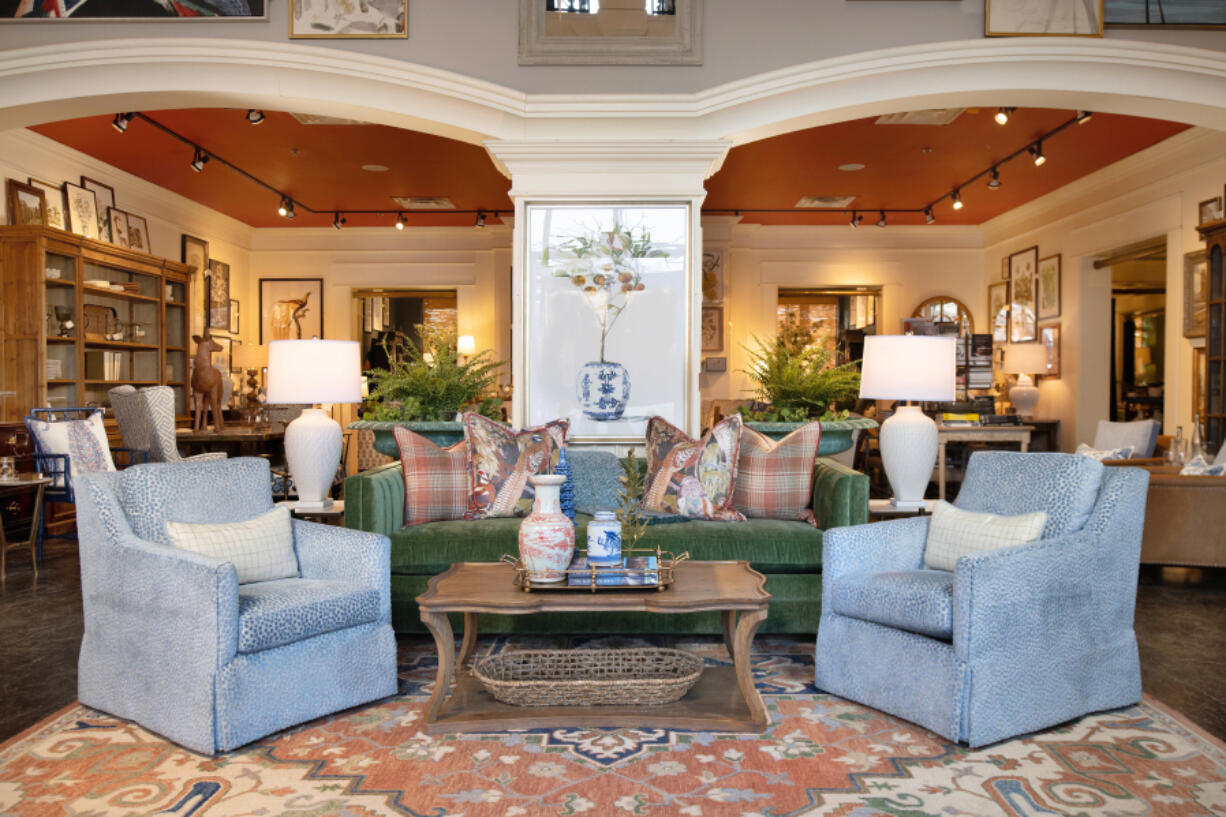 A stunning fern green sofa is paired with two exquisite blue chairs, creating a captivating and inviting seating arrangement.