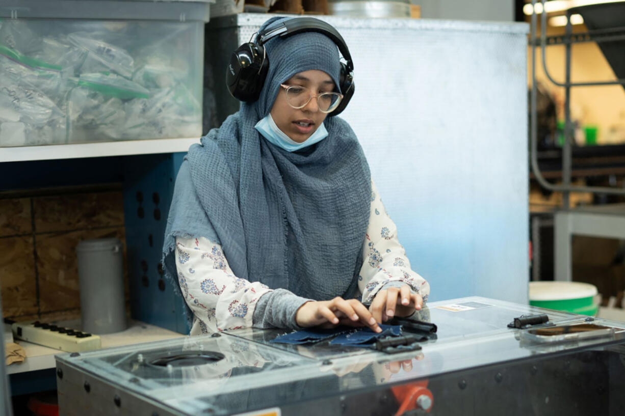 University of Minnesota, Duluth master&rsquo;s student Hira Durrani feeds a piece of fabric into the Fiber Shredder machine on July 10. The machine was developed by Abigail Clarke-Sather and her team.