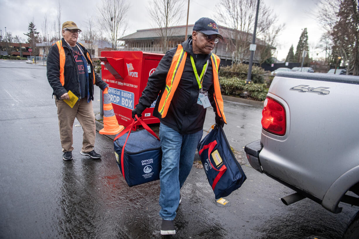 John Waterbury, left, and Fabian Jackson of the Clark County Elections Office collect official ballots in downtown Vancouver on Tuesday morning, March 12, 2024.