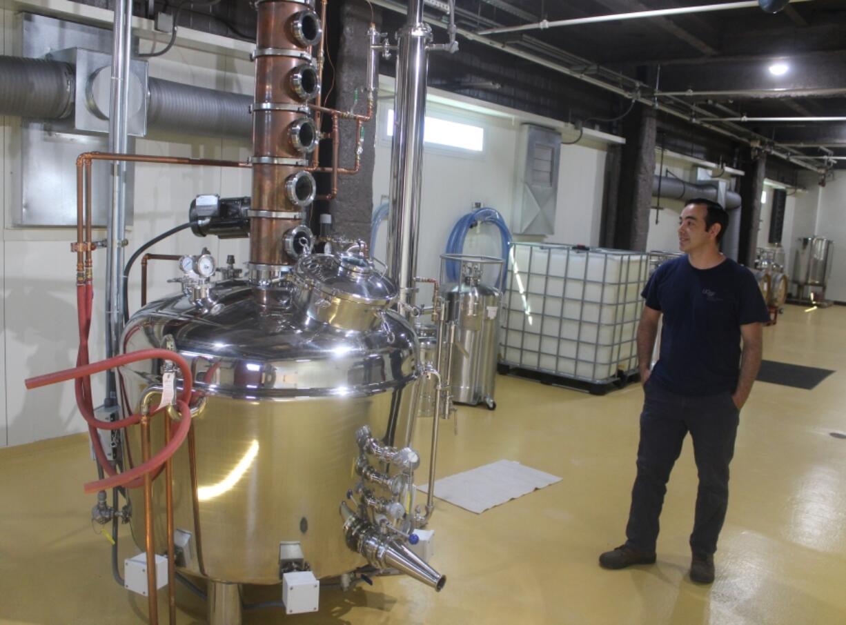 Rediviva lead distiller Daniel Ruiz stands next to the distillery&rsquo;s 150-gallon pot still on July 11 in Washougal.