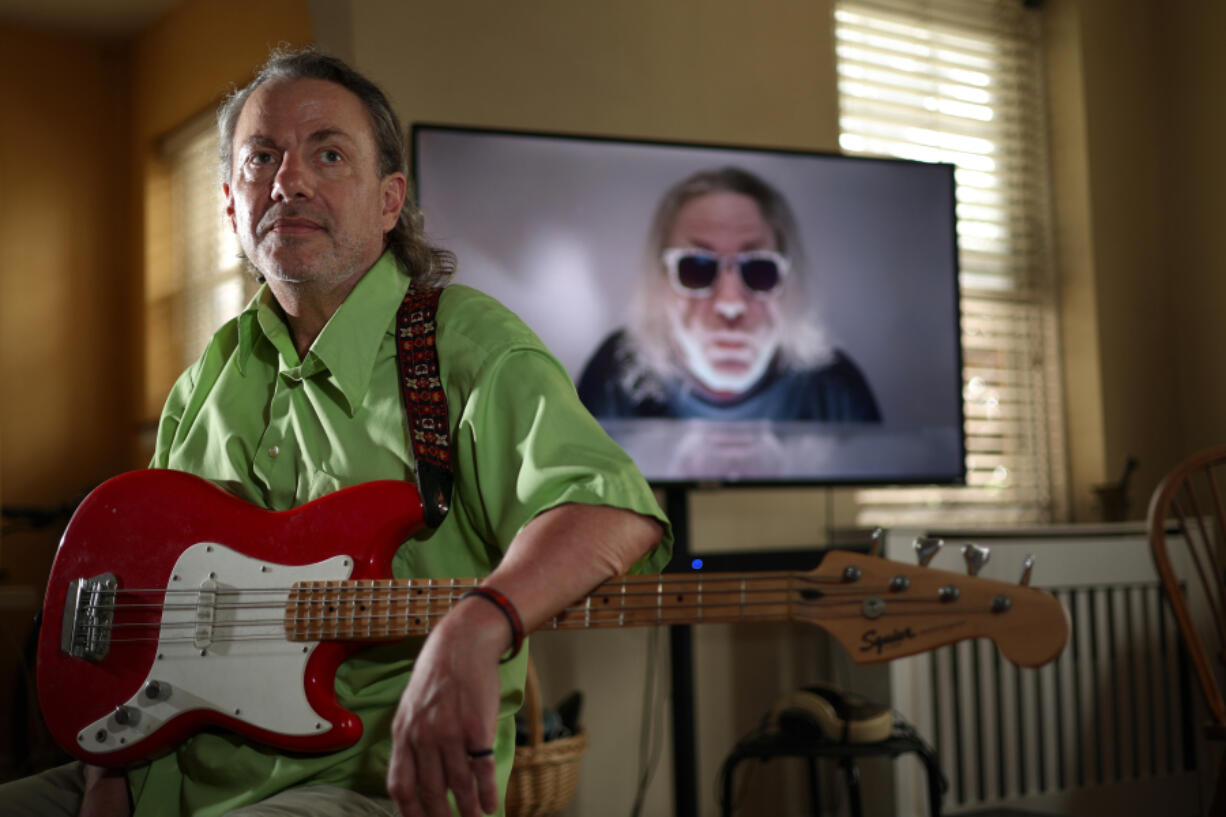 Artist, poet and musician J.J. Tindall in his home on July 9 in Oak Park, Ill. Behind him on the screen is one of his YouTube videos.