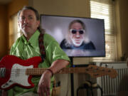 Artist, poet and musician J.J. Tindall in his home on July 9 in Oak Park, Ill. Behind him on the screen is one of his YouTube videos.