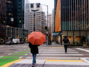 A person walks near Amazon office buildings near 7th Avenue and Blanchard Street on Jan. 17, 2023, in Seattle.