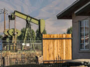 A pumpjack sits near homes in Arvin, California.