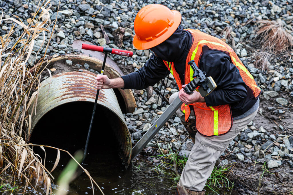 Austin Richard, stewardship ecologist for the Tulalip Tribes, measures the BNSF culvert on the Edgecomb Creek in Arlington, Washington, on Jan. 5, 2024.