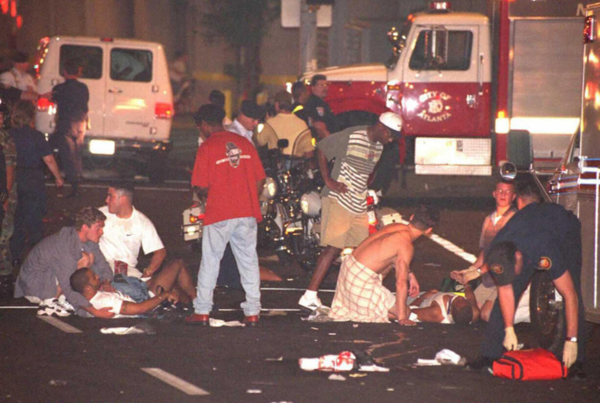 People tend to the injured after an explosion  rocked Centennial Park, built for visitors to the Olympic Games in downtown Atlanta, early on July 27, 1996.