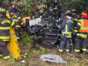 Vancouver firefighters extract a driver from a car that flipped on Highway 14 in east Vancouver on Monday afternoon.