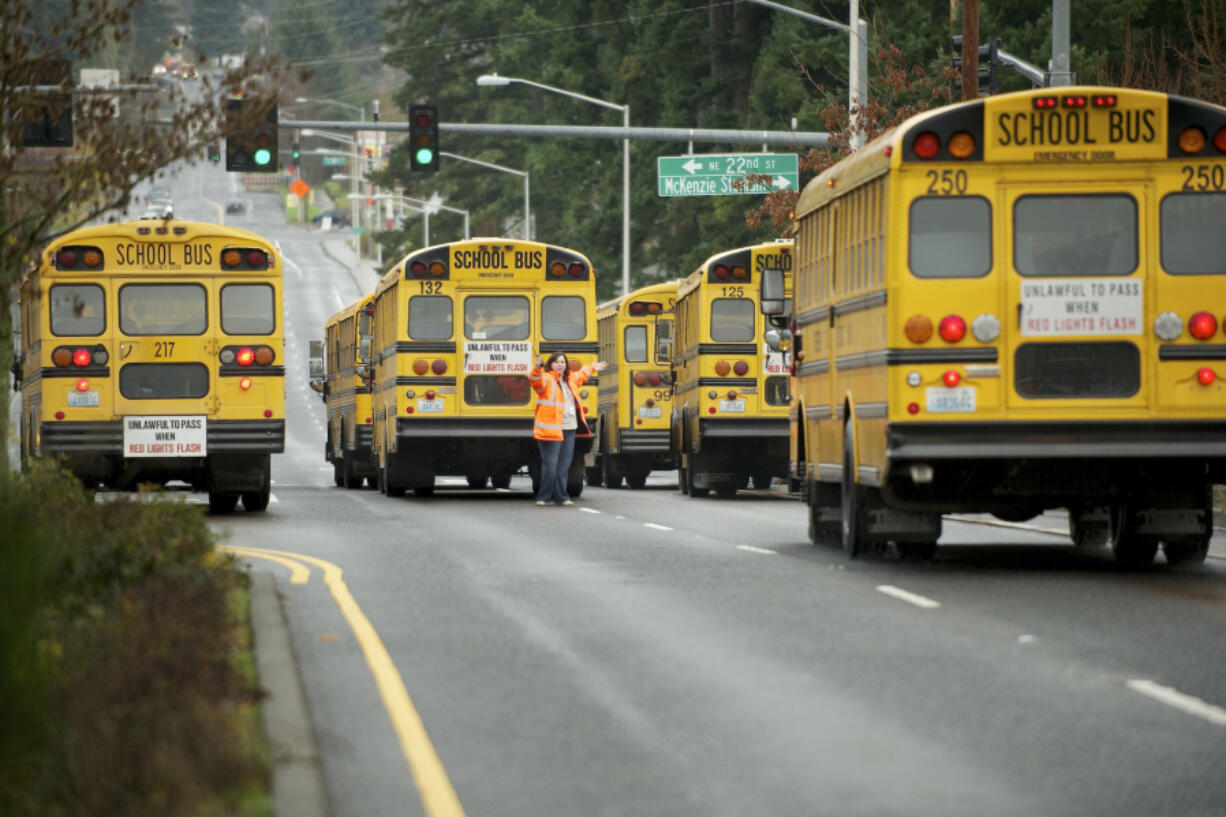 Yvonne Gaylord, a driver trainer and safety person with Evergreen Public Schools, directs bus drivers outside Evergreen High School on Dec. 12, 2012, in Vancouver. Clark County school districts are still working to develop a larger, consistent pool of regular and substitute bus drivers as the school year draws near.