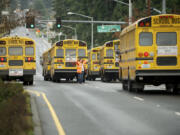 Yvonne Gaylord, a driver trainer and safety person with Evergreen Public Schools, directs bus drivers outside Evergreen High School on Dec. 12, 2012, in Vancouver. Clark County school districts are still working to develop a larger, consistent pool of regular and substitute bus drivers as the school year draws near.