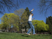 Jeff Way of Vancouver, right, keeps his balance as he enjoys slacklining in the sunshine with his roommate, Matthew Nebel, not pictured, Friday afternoon, April 1, 2016 at Esther Short Park. Yesterday's blue skies and warm temperatures made it a good day for residents to kick off their shoes and get outdoors.