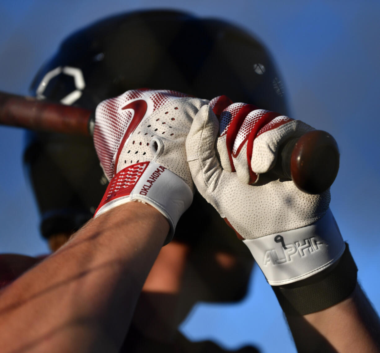 Gloves reading "Oklahoma" sit on the hands of Ridgefield Raptors' Patrick Engskov. Though he recently announced he'll be transferring to Arkansas State, Engskov is part of a pipeline the Raptors have with the Oklahoma Sooners baseball program.