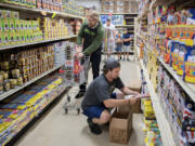 Phillip Caddy of Portland, left, shops for the upcoming holiday as Cody Lawrentz of Blackjack Fireworks stocks shelves on Wednesday morning. Along with using fireworks safely, county officials urge residents to protect the environment by sweeping up all spent fireworks.