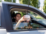 Volunteer Almendra Velazquez installs a heat-measuring sensor on a car window Friday at the Center for Community Health. Velazquez and fellow volunteer Rebecca Small drove a one-hour route as part of Clark County Public Health's heat-mapping project. The data could help decide where cooling centers should be.