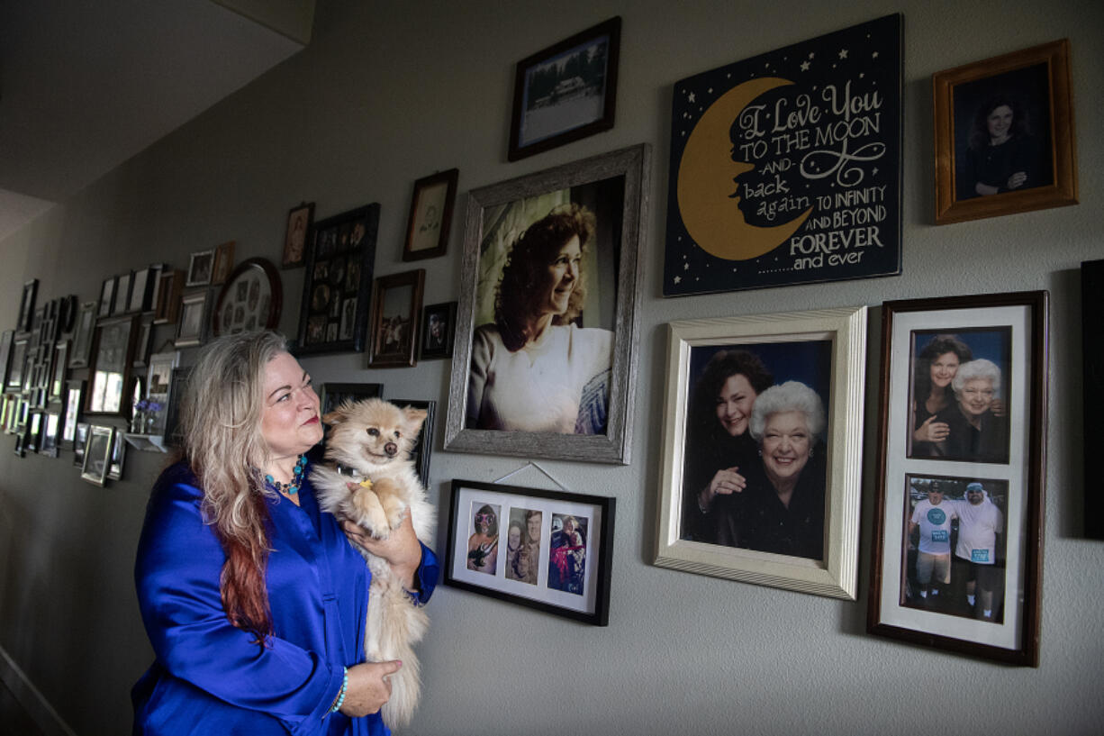 Family caregiver advocate Christina Keys remembers her mom, Patricia Keys, while looking at her portrait in the front hallway of her Vancouver home Monday afternoon. Christina Keys quit her job 12 years ago to take care of her mother, who died in December 2022. More than 120 organizations and advocates for workers have launched a statewide campaign to defeat ballot Initiative 2124, which would make opting into the long-term care coverage tax voluntary. Also pictured is her mom&rsquo;s service dog, Puddy, 13. &ldquo;You weren&rsquo;t a burden,&rdquo; she said to her late mother.