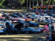 People stroll among classic cars Friday, during one of Alderbrook Park&rsquo;s regular Friday night cruise-ins.