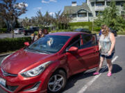 Stephanie Bradshaw, right, gets into her car with her daughter Olivia, 13, on Wednesday at Bradshaw&rsquo;s apartment complex in east Vancouver. Bradshaw is a special education paraeducator in Evergreen Public Schools and drives for Uber and Lyft on the side to make extra money. During the summer, driving is the main source of income that helps pay for rent and bills. Recently, she was rear-ended &mdash; taking her car out of commission for ride-sharing until it is repaired.
