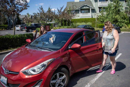 Stephanie Bradshaw, right, gets into her car with her daughter Olivia, 13, on Wednesday at Bradshaw&rsquo;s apartment complex in east Vancouver. Bradshaw is a special education paraeducator in Evergreen Public Schools and drives for Uber and Lyft on the side to make extra money. During the summer, driving is the main source of income that helps pay for rent and bills. Recently, she was rear-ended &mdash; taking her car out of commission for ride-sharing until it is repaired.