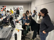 Sue Morrow, center in black sweater, looks over photos that were edited and sequenced by participants in The Kalish Visual Storytelling Workshop last June in Rochester, N.Y.