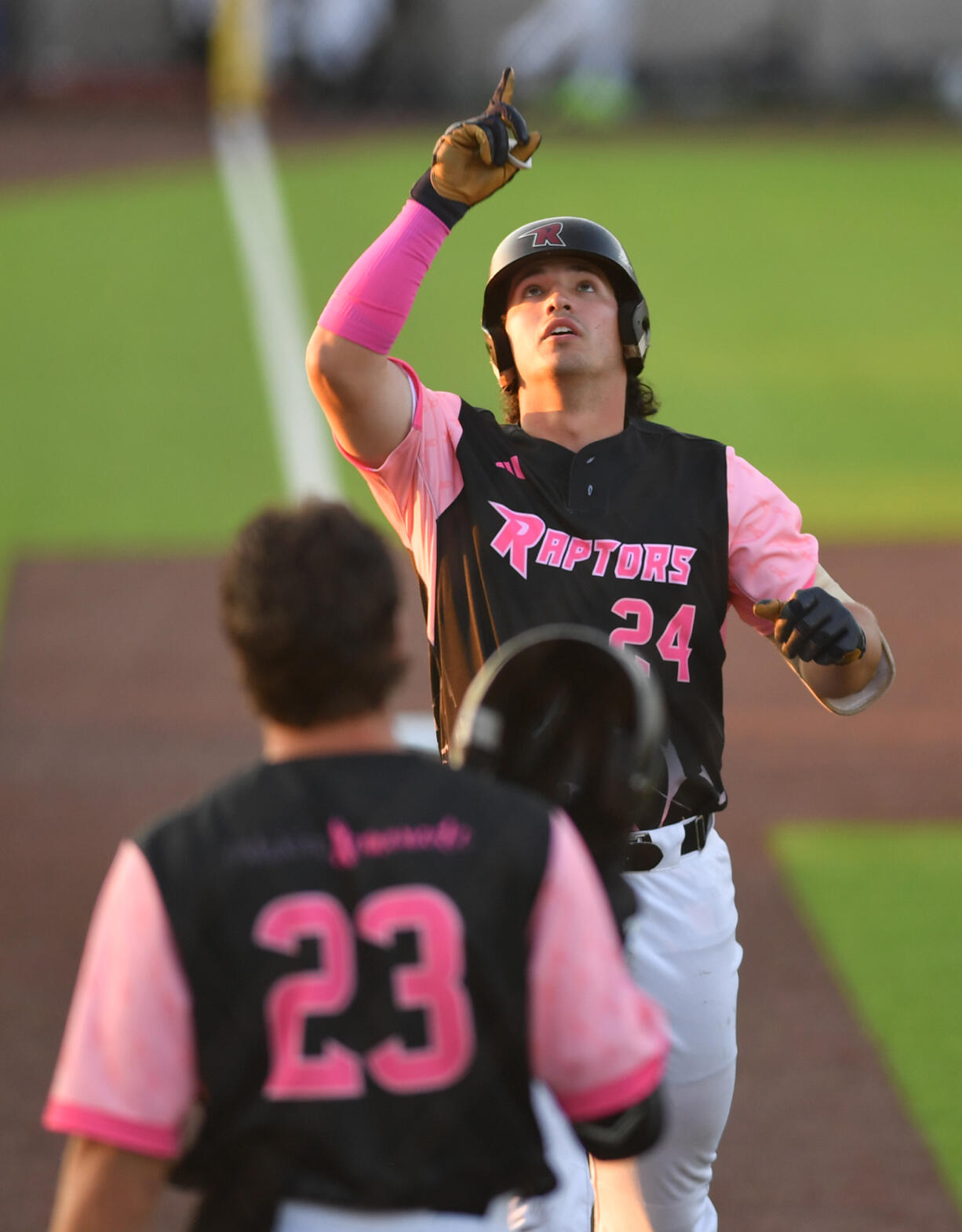 Ridgefield's Hunter Katschke (24) points skyward after hitting a home run Thursday, July, 25, 2024, during a game between the Raptors and the Corvallis Knights at the Ridgefield Outdoor Recreation Complex.