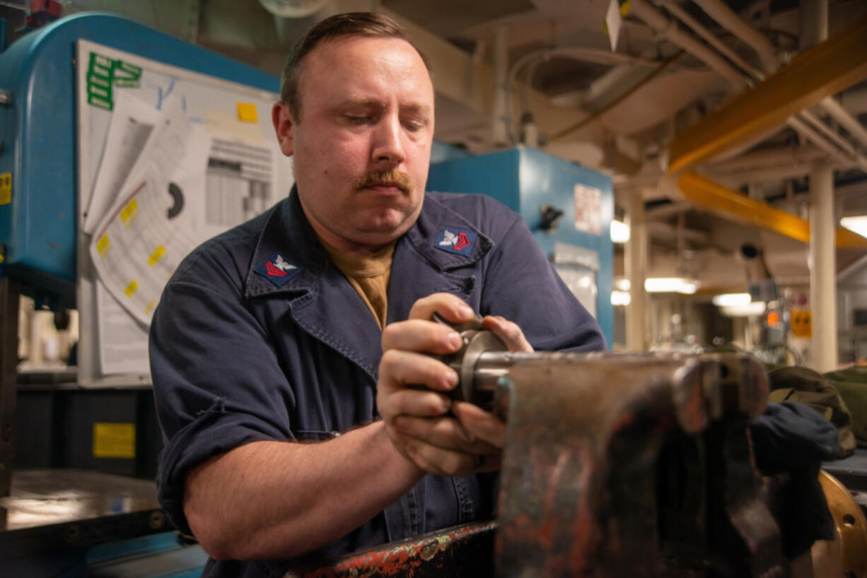 Machinery Repairman 1st Class Walter Hurt, from Amboy, attaches a bevel gear to a stanchion shaft in the machinery repair shop aboard the aircraft carrier USS Nimitz in the Pacific Ocean on, July 26.