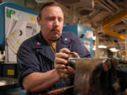 Machinery Repairman 1st Class Walter Hurt, from Amboy, attaches a bevel gear to a stanchion shaft in the machinery repair shop aboard the aircraft carrier USS Nimitz in the Pacific Ocean on, July 26.