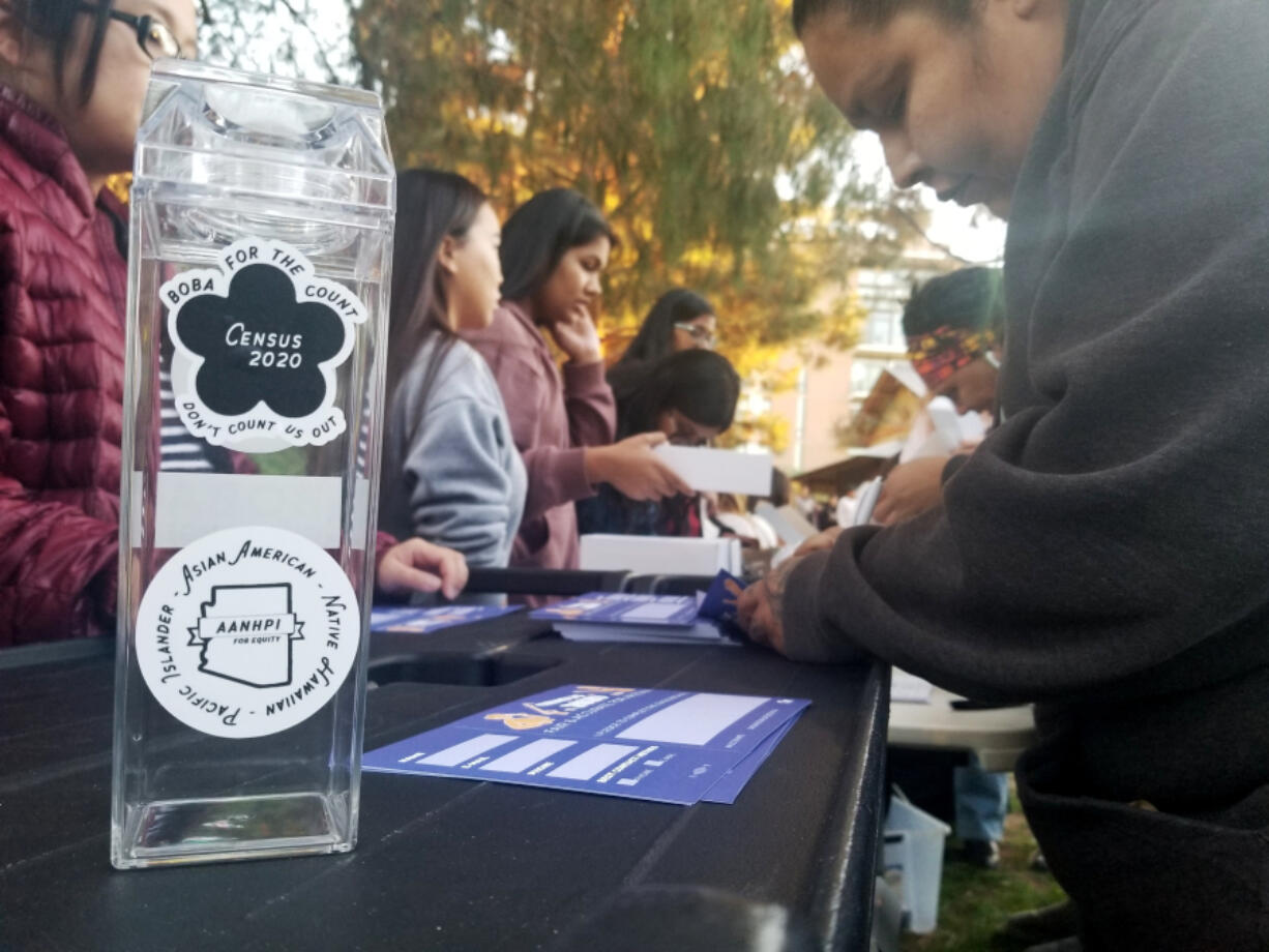 FILE - A woman fills out a pledge card for the U.S. Census in exchange for a reusable boba tea carton at a boba drink competition in Phoenix on Jan. 3, 2020. According to a new study released in June 2024, adding a citizenship question to the census reduces the participation of people who aren&rsquo;t U.S. citizens.