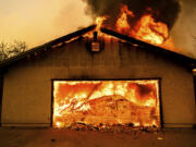 Flames consume a garage as the Thompson Fire burns in Oroville, Calif., Tuesday, July 2, 2024. An extended heatwave blanketing Northern California has resulted in red flag fire warnings and power shutoffs.