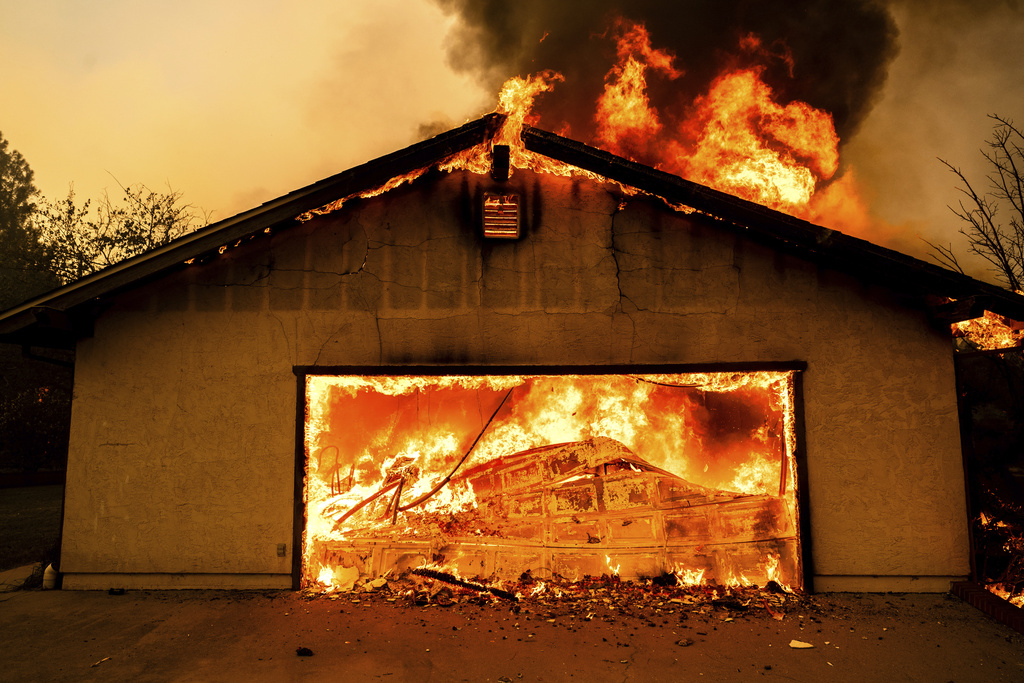 Flames consume a garage as the Thompson Fire burns in Oroville, Calif., Tuesday, July 2, 2024. An extended heatwave blanketing Northern California has resulted in red flag fire warnings and power shutoffs.