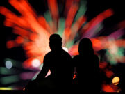 FILE - People watch distant fireworks from a park on July 4, 2022, in Kansas City, Mo. Warehouse membership club Costco said it would be closed on July 4th, 2024, but the vast majority of major national retailers will be open, with some offering promotional sales to lure customers.