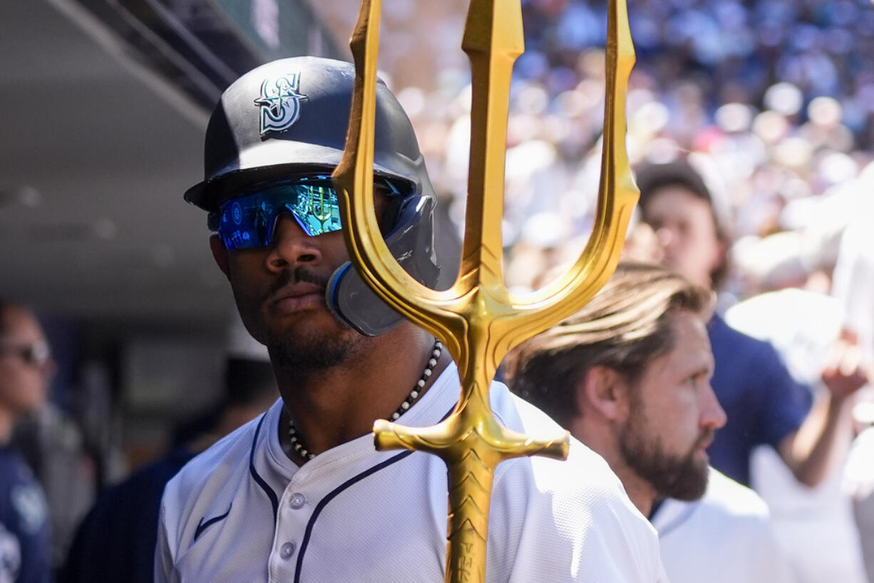 Seattle Mariners' Julio Rodríguez holds a trident in the dugout after his solo home run against the Baltimore Orioles during the fifth inning of a baseball game Thursday, July 4, 2024, in Seattle.